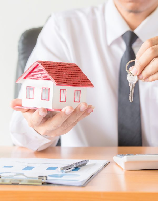 House key in home insurance broker agent’s hand protection House key in home insurance broker agent's hand protection or in salesman person giving to buyer customer